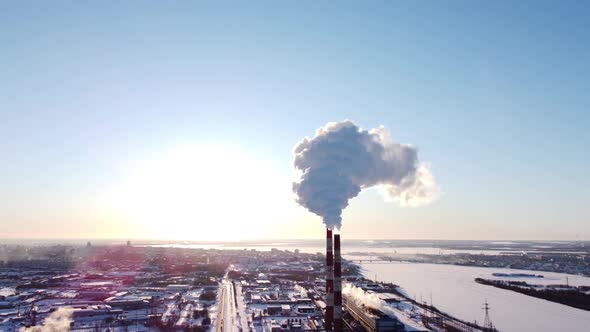 Chimneys of a Factory or Power Plant Produce Smoke at Sunrise Aerial View From a Drone