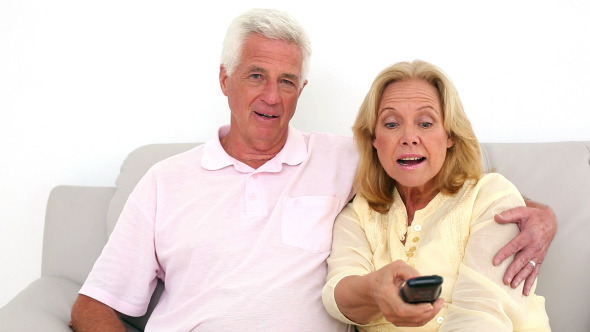 Retired Couple Watching Television On The Couch 1
