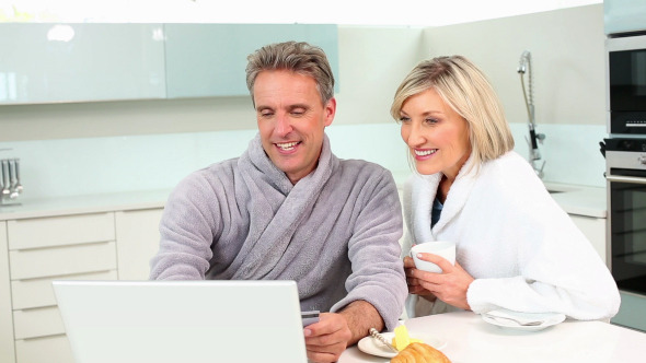 Mature Couple Shopping Online At Breakfast