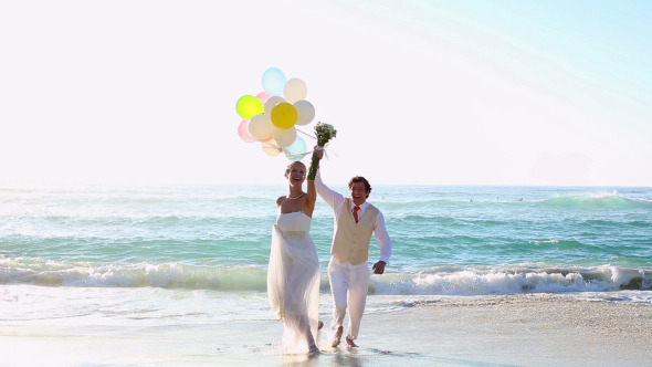 Newlyweds Laughing And Playing With Balloons