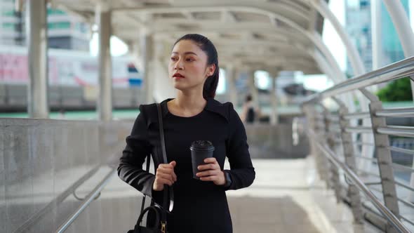 woman holding a cup of coffee walking in the city