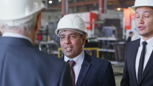 Group of Business People in Hardhats Discussing Something alt