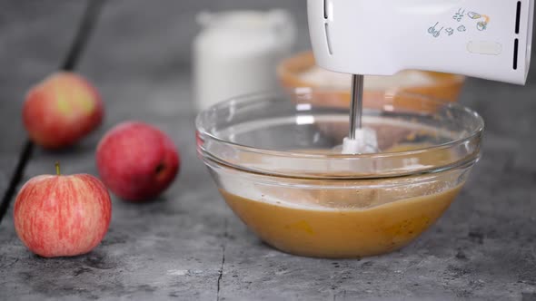 Adding flour into mixing bowl. Making apple cake.
