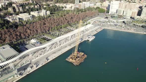 Paseo del muelle or pier walk on seafront in Malaga port area, Andalucia in Spain. Aerial top-down c