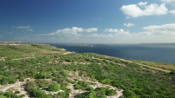 AERIAL: Revealing Comino Island and Greenery Plains of Gozo Island near Blue Mediterranean Sea