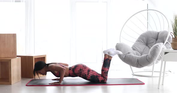 Black woman making lunges training at home. Home fitness and wellness concept.