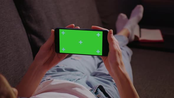 The smartphone in the hands of a young woman alt