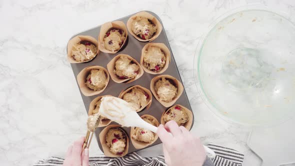 Flat lay. Step by step. Scooping dough into tulip muffin liners with mixture scoop to bake cranberry alt