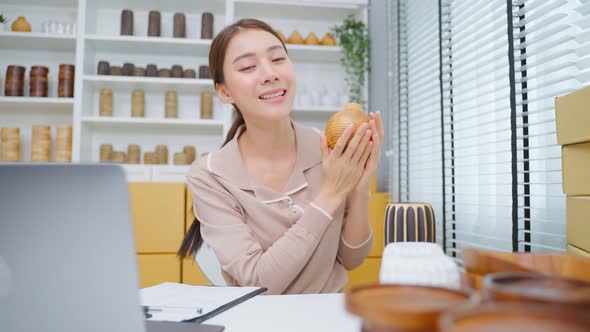 Asian beautiful woman sell vase product online live streaming at home. alt