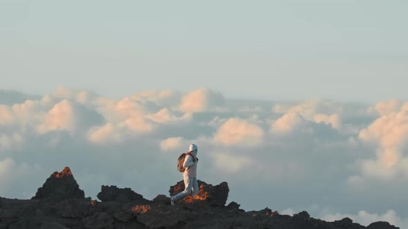 Traveler Exploring High Mountain Summit Above Clouds at Sunset Slow Motion alt