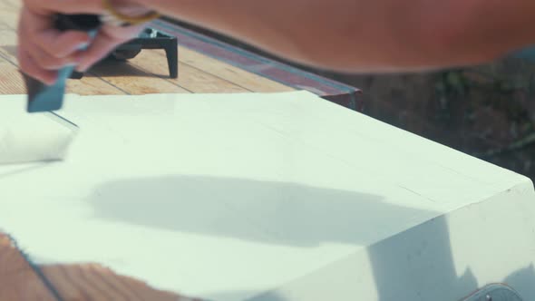 Applying white primer paint on wood boat wheelhouse cabin roof planks alt