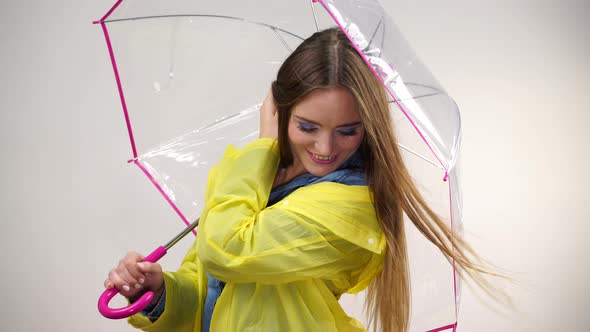 Woman in Raincoat Holds Umbrella 