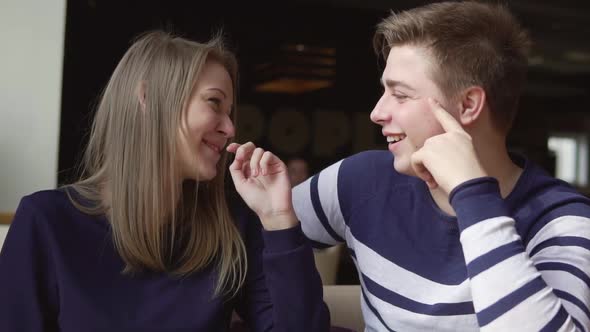 Young Attracrive Couple is Sitting at the Cafe Talking and Laughing alt