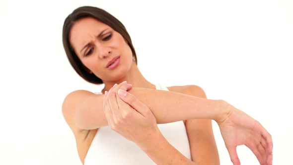 Fit Model In Sports Bra Holding Her Sore Elbow alt