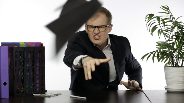 Businessman Working in Office. Boss Shouting and Throws Papers Into the Camera alt