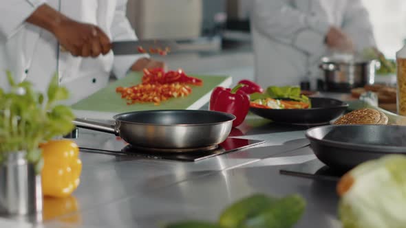 Male Chef Preparing Chopped Bell Pepper in Restaurant Kitchen alt