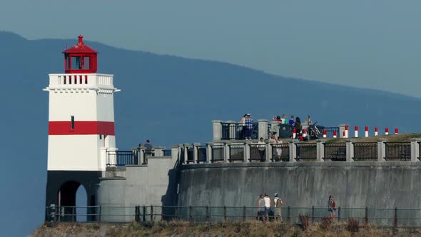 People Walking Around Lighthouse On Hot Day alt
