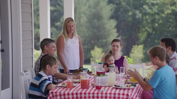 Group of people eating and enjoying a backyard barbeque