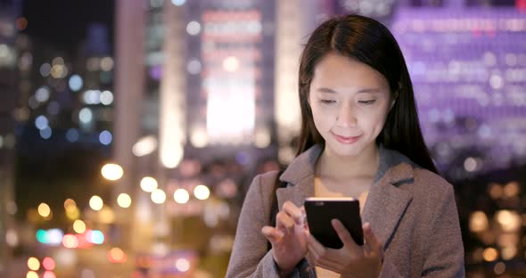 Woman read on smart phone in city alt