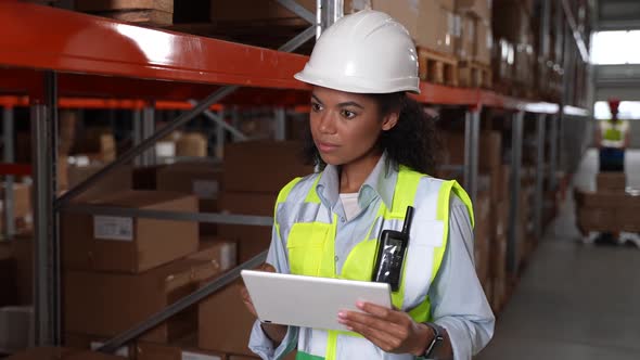 Female with Tablet Taking Inventory in Warehouse alt