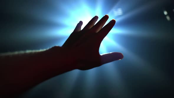 Hand Reaching Out to Cover Shinning Spot Light alt