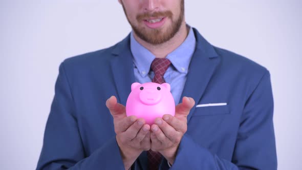 Closeup of Happy Bearded Businessman Holding Piggy Bank