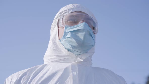 Close-up Portrait of Young Caucasian Man in White Safety Suit and Protective Eyeglasses at the alt