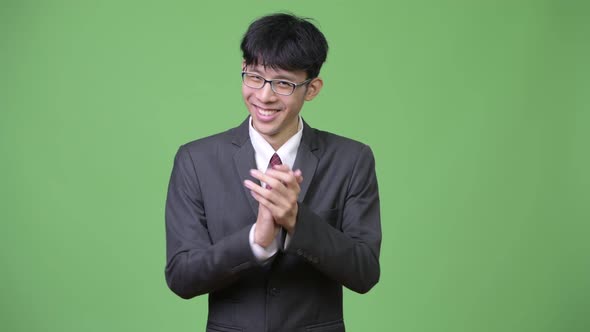 Young Happy Asian Businessman Smiling While Clapping Hands alt
