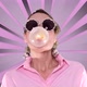 Woman With Party Glasses Chewing Gum And Make Bubble On Spinning Pink Rays Background - VideoHive Item for Sale