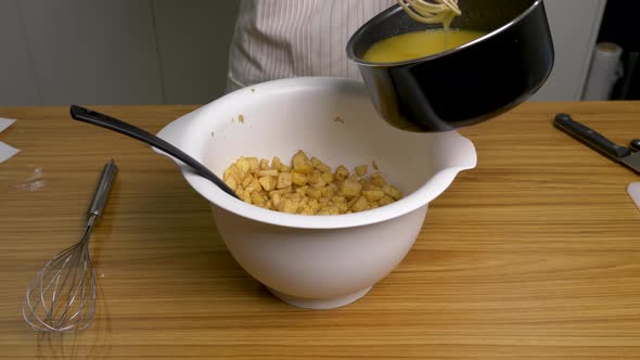 Pouring freshly made liquid on sliced apples for crumble pie cooking alt