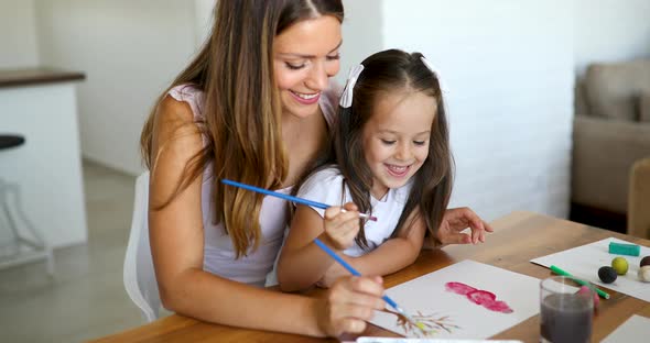 Little Girl Painting with Her Mother at Home