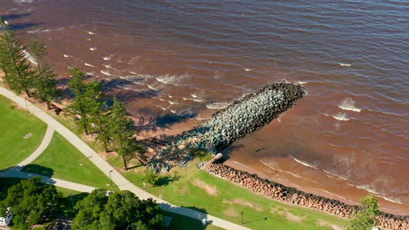 A foreshore or beach withing waves and a rock jetty, Located in Redcliffe, Brisbane, Australia. alt