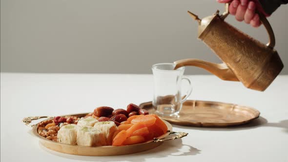 Turkish Tea and Sweets Hot Drink in Traditional Armudu Glass Closeup alt