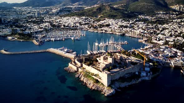 View from drone on full of yachts Bodrum harbour and ancient Kalesi castle in Mugla in Turkey alt