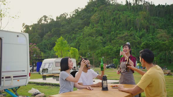 Group of Asian man and woman are having new year party outdoor drinking bottle of beer with smile. alt