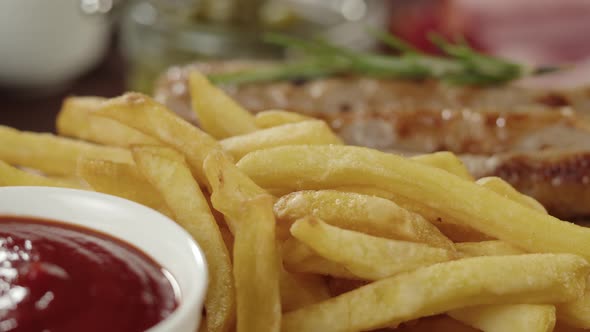 Bowl with Tomato Sauce and Smoked Sausages with Rotating French Fries Closeup alt
