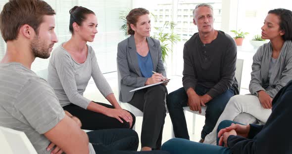 Group therapy in session sitting in a circle alt