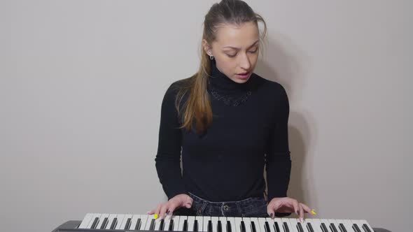 Female Vlogger Streaming Teaching Video Blog About Playing on Synthesizer, Piano