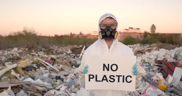 Man in Coverall Holding Anti Poluttion Sign alt