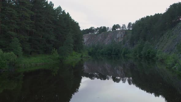 Aerial View of the River with Smooth Water and Forest on the Banks alt