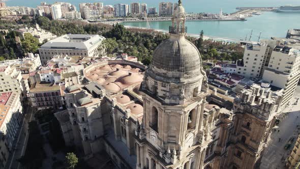 Orbiting Cathedral bell tower revealing beautiful Malaga Coastline, Spain