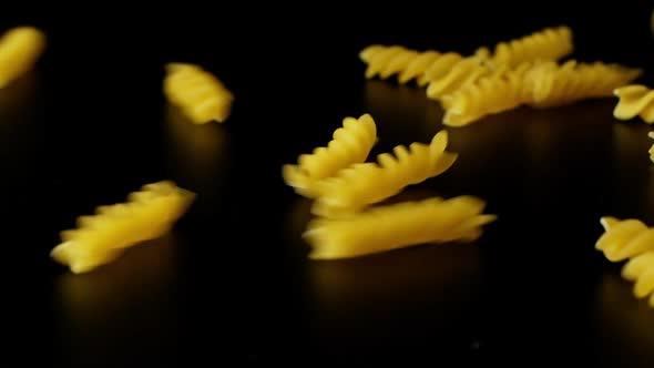 Macaroni Pasta Falling Down black background, slow motion