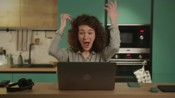 Young 20s Adult Student Recieves Good News on Her Laptop in Her Kitchen at Home alt