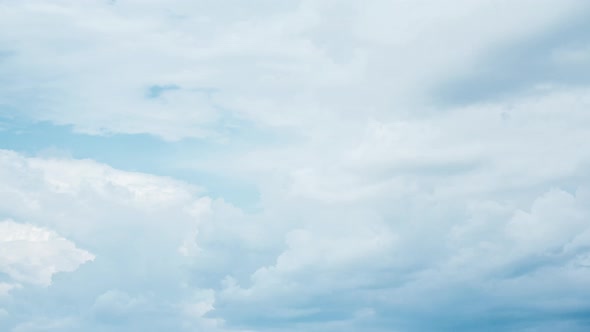 Timelapse of white fluffy clouds. Aerial view of light blue sky