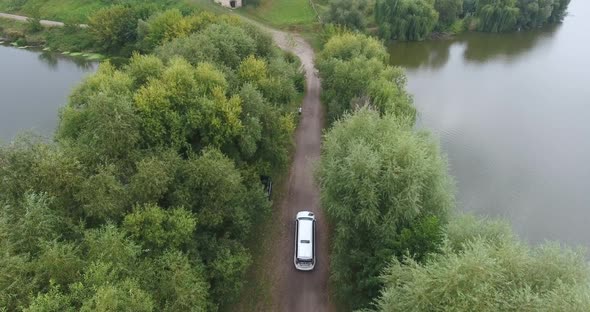 Wedding white limousine rides through the Park near the lake. Top view, shooting from a copter.