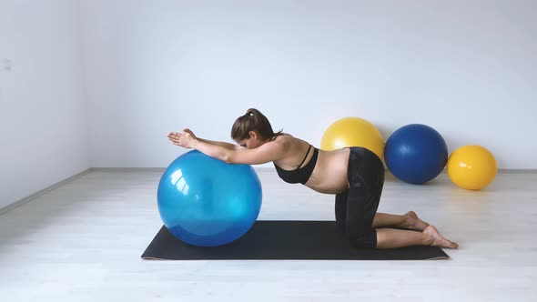 Slow motion shot of pregnant woman during exercise with gymnastic ball