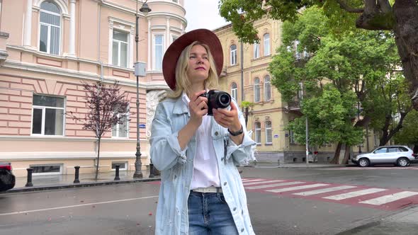 Photographer Takes a Pictures on Camera in the City