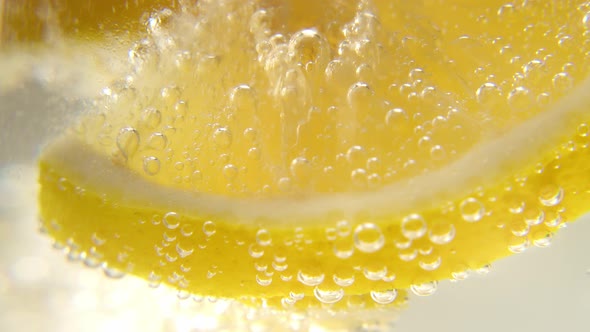Fresh Lemon is Added to a Glass of Sparkling Ice Water Making a Refreshing Soft Drink alt
