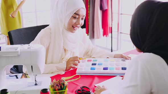 Muslim women fashion designers are in process of creating new clothes collection. alt