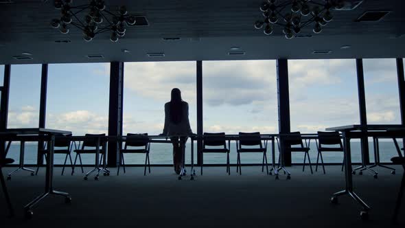 Woman Silhouette Enjoying Break in Conference Room alt